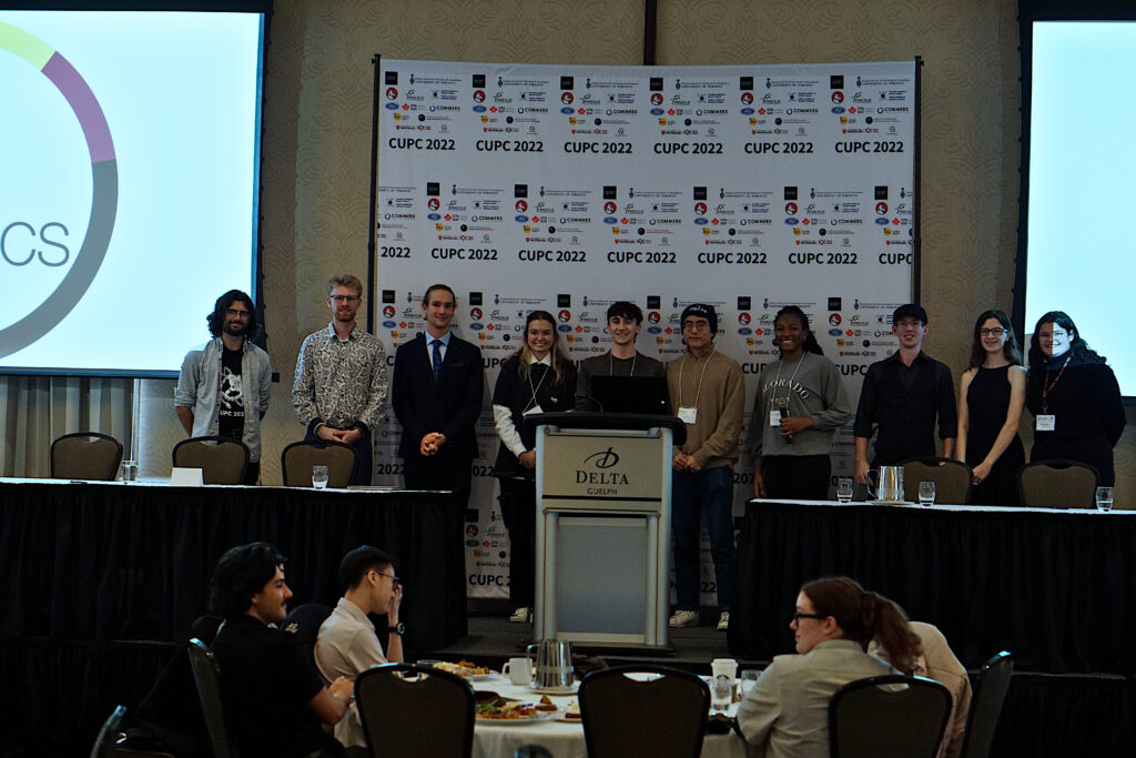 Photo of CUPC 2022 poster presentation competition winners Lana Bozanic, Noah Baker, and Yeh-In Kang, flanked by CUPC 2022 organizing team members.