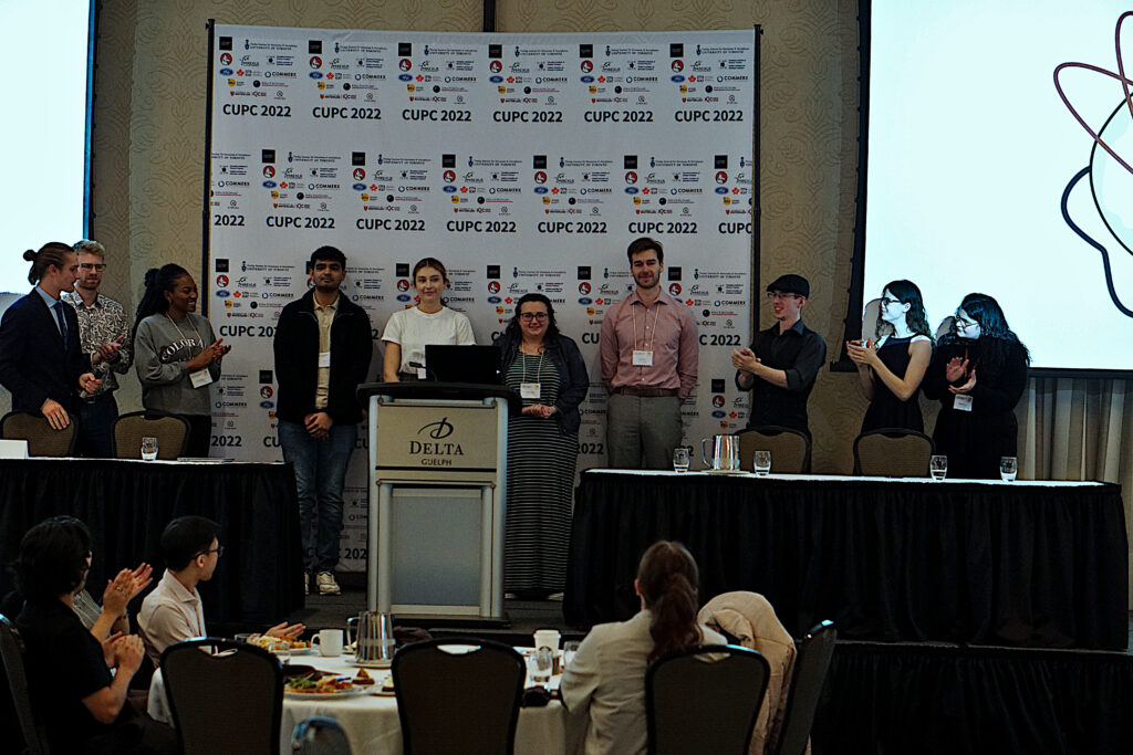 Photo of CUPC 2022 oral presentation award winners Dhruval Shah, Taren Ginter, Victoria Arbour, and Liam Morrison, flanked by CUPC 2022 organizing team members.
